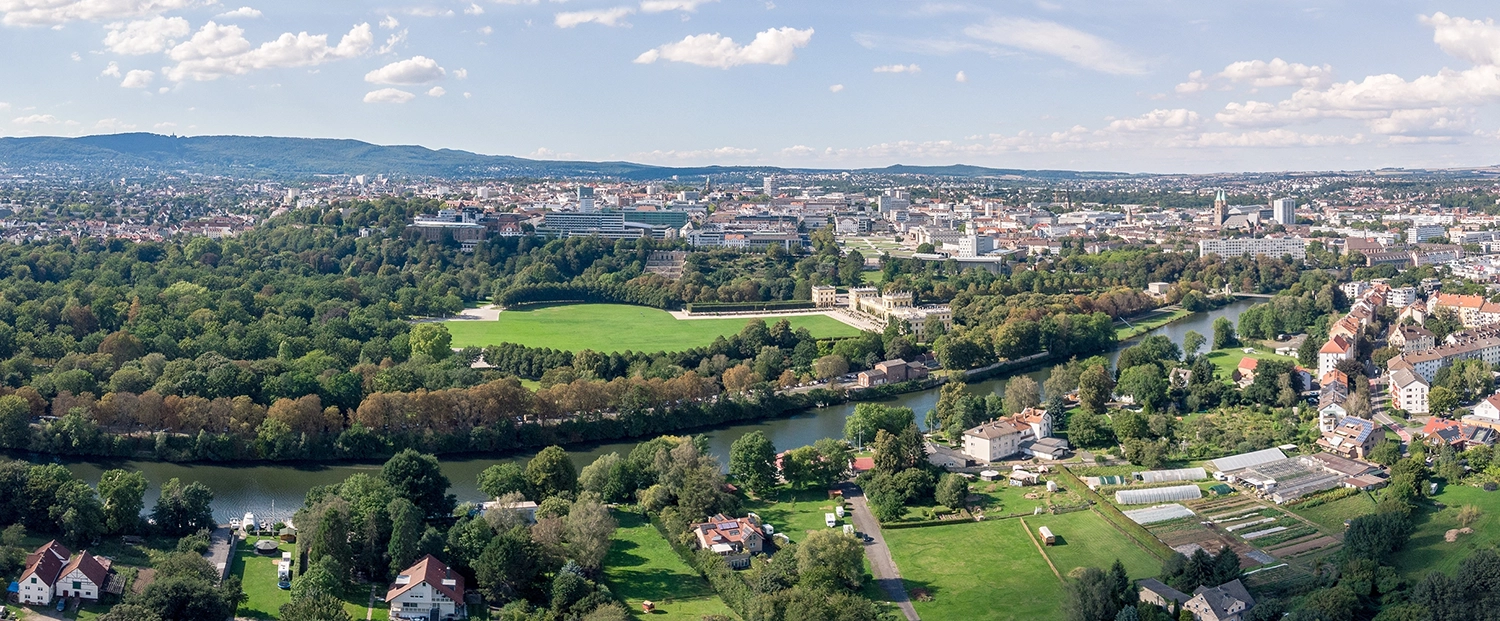 Luftaufnahme von Kassel mit dem Aue-Park und Orangerie im Fokus.